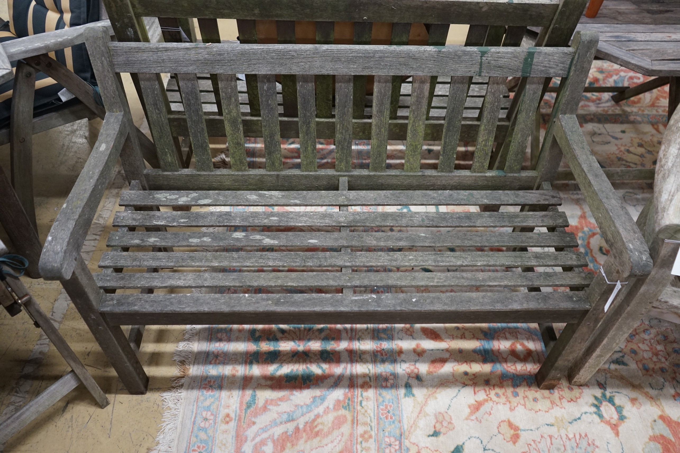 A weathered teak garden bench, length 122cm, depth 54cm, height 83cm